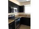 Cozy kitchen features black cabinets, stainless steel microwave, and laminate countertops at 2725 S Nellis Blvd # 1201, Las Vegas, NV 89121