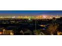 Night view of homes with city lights in the background at 2736 Hartwick Pines Dr, Henderson, NV 89052