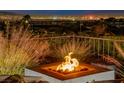 Backyard features a cozy fire pit with amazing city views at night, creating an inviting outdoor ambiance and great entertainment at 2736 Hartwick Pines Dr, Henderson, NV 89052