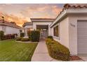 Front entrance of a single-story home with gray door and landscaping at 1613 Shadow Rock Dr, Las Vegas, NV 89117