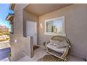 Small balcony with a wicker chair and cushions at 2101 Quartz Cliff St # 207, Las Vegas, NV 89117