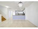 Bright living room with tile flooring, open to a modern kitchen with stainless steel appliances at 2120 Waterlily View St, Henderson, NV 89044