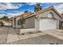 Charming single-story home featuring a two-car garage, desert landscaping, and a tile roof at 2668 Alwoodley Cir, Las Vegas, NV 89142