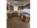 Galley kitchen with wood cabinets and tile flooring at 4801 Fiesta Lakes St, Las Vegas, NV 89130