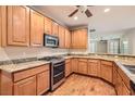 Modern kitchen with wood cabinets, granite counters, and stainless steel appliances at 5124 Pensier St, Las Vegas, NV 89135