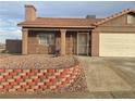 Tan colored stucco house with a two-car garage at 609 W Victory Rd, Henderson, NV 89015