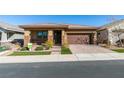 One-story home with brown garage door and stone accents at 752 Drammatico Pl, Henderson, NV 89011