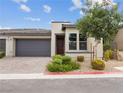 Contemporary house exterior, featuring a paved driveway and landscaping at 9911 Spinel Pl, Las Vegas, NV 89143