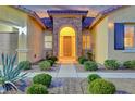 Inviting entryway with a stone arch and well-manicured landscaping at 10290 Hawks Wing St, Las Vegas, NV 89178