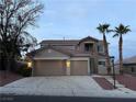 Two-story house with a two-car garage, palm trees, and mature trees at 10488 Beckaville Ave, Las Vegas, NV 89129