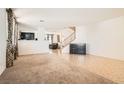 Large open living area with tile and carpet flooring, a staircase and view to other living spaces at 11276 Accademia Ct, Las Vegas, NV 89141