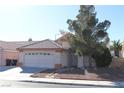 Single-story house with a two-car garage and a landscaped front yard at 1235 Pagentry Dr, North Las Vegas, NV 89031