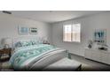 Bright bedroom with a queen bed, soft carpet, and a large window with blue-toned decor and modern furniture at 129 Castanet Ln # Lot 190, Henderson, NV 89015