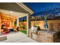 Outdoor kitchen and patio area with seating, providing an entertaining space at 156 Ozuna Ct, Las Vegas, NV 89183