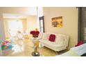 Bright living room with white couch, dining area, and marble floors at 1972 Weenap Dr, Las Vegas, NV 89108