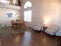 Bright dining room with hardwood floors, chandelier, and seating for six at 2525 Huber Heights Dr, Las Vegas, NV 89128