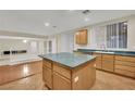 Kitchen island, light wood cabinets, and a view into the living area at 295 Blackstone River Ave, Las Vegas, NV 89148