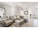 Bright and airy living room with gray sectional sofa and whitewashed brick accent wall at 5370 Cholla Cactus Ave, Las Vegas, NV 89141