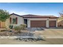 Single story home with a three-car garage and landscaped yard at 5805 Vibrant Violet Ct, Las Vegas, NV 89130