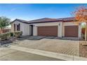 Single-story house with three-car garage and brick driveway at 5805 Vibrant Violet Ct, Las Vegas, NV 89130