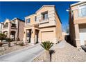 Beige two-story house with attached garage and desert landscaping at 6074 Lazarro Ct, Las Vegas, NV 89139