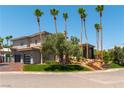 Home exterior featuring a three car garage and desert landscaping at 7880 Dana Point Ct, Las Vegas, NV 89117