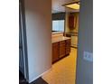 Partial view of kitchen with wood cabinets and tile flooring at 833 Aspen Peak Loop # 2225, Henderson, NV 89011