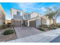 Two-story home with gray and stone accents, two-car garage, and landscaped front yard at 8595 Old Daylily Ln, Las Vegas, NV 89113