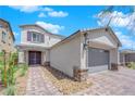 Two-story house with gray exterior, paver walkway, and landscaping at 1606 Dire Wolf Ave, North Las Vegas, NV 89084