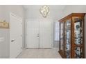 Bright entryway with double doors, tile flooring, and display cabinet at 2413 Hidden Glen Ct, Las Vegas, NV 89134