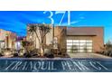 Contemporary home featuring drought resistant landscaping and an oversized 2-car garage with a glass grid door at 371 Tranquil Peak Ct, Henderson, NV 89012