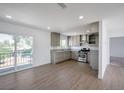 L-shaped kitchen with light wood floors and access to a patio at 3950 Ventura Way, Las Vegas, NV 89121