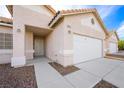 Front entry and attached two-car garage with walkway at 4313 Beach Cliff Ave, North Las Vegas, NV 89031