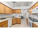 Bright kitchen with wood cabinets, gas range, and tile floor at 5728 Palma Del Sol Way, Las Vegas, NV 89130