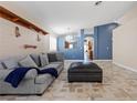 Living room with tiled floors, gray sofa, and a view into the kitchen at 6501 Grand Oaks Dr, Las Vegas, NV 89156