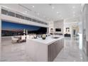 Modern kitchen featuring an island, bar seating, marble floors, and sliding glass doors with a city view at 665 Overlook Rim Dr, Henderson, NV 89012
