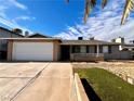 House exterior with a white garage door and artificial turf at 730 Brick Dr, Henderson, NV 89002