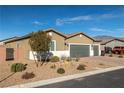 Single-story house with three-car garage, desert landscaping, and a tree at 74 Wildcat Ave, Pahrump, NV 89060