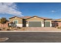 Single-story house with three-car garage and desert landscaping at 74 Wildcat Ave, Pahrump, NV 89060