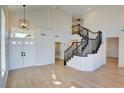 Two-story foyer with a grand staircase and light hardwood floors at 8466 Lambert Dr, Las Vegas, NV 89147