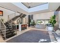 Spacious living room with high ceilings, a modern sectional sofa, and a fireplace at 103 San Martino Pl, Henderson, NV 89011