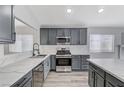 Modern kitchen with gray cabinets, white countertops, and stainless steel appliances at 524 Blackbird Knoll Ct, North Las Vegas, NV 89084