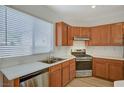 Charming kitchen features wood cabinets, stainless steel appliances, and double sink under a sunny window at 9204 Weeping Hollow Ave, Las Vegas, NV 89178