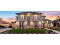 Beautiful two-story home with decorative balconies, manicured lawn and stone facade at 9605 Verlaine Ct, Las Vegas, NV 89145