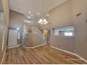 Two-story living room with hardwood floors and chandelier at 10279 Montes Vascos Dr, Las Vegas, NV 89178