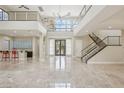 Two story high ceiling living room with marble floors and modern staircase at 101 San Martino Pl, Henderson, NV 89011