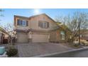 Charming two-story home with a three-car garage, stone accents, and a well-maintained front yard at 10729 Beecher Park Ave, Las Vegas, NV 89166