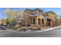 House's exterior features stone and stucco finishes, landscaping, and a street view at 10729 Beecher Park Ave, Las Vegas, NV 89166