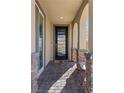 Inviting front porch featuring stylish stone pillars, a decorative chair and a paved entrance at 10729 Beecher Park Ave, Las Vegas, NV 89166