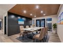 Contemporary dining room with a white table, seating for six, modern lighting, and dark paneled wall at 1630 Westwood Dr, Las Vegas, NV 89102